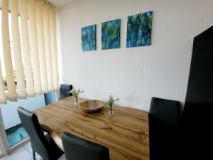 Un comedor con mesa y sillas de madera. en 2 Zimmer für 3-4 Person , Klima, Parkplatz, en Mülheim an der Ruhr