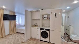 una pequeña cocina con lavadora en una habitación en Luxury on Gogol, en Karagandá