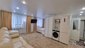 sala de estar con sofá, lavadora y secadora en Luxury on Gogol, en Karagandá