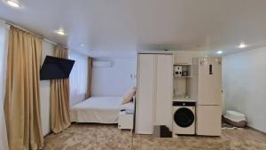 1 dormitorio pequeño con 1 cama, lavadora y secadora en Luxury on Gogol, en Karagandá