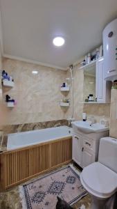 Un baño con inodoro, bañera y lavabo. en Luxury on Gogol, en Karagandá