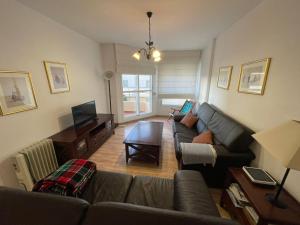 a living room with a couch and a television at Apartamento a unos pasos de la Playa (Rota) in Rota