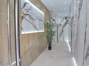 a hallway in a building with plants on the walls at Pass the Keys Mill Conversion Flat Mins from City Bars Shops in Manchester