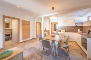 Una cocina y un comedor con mesa y sillas de madera. en Glögglhof, en Appiano sulla Strada del Vino 16 fotos más