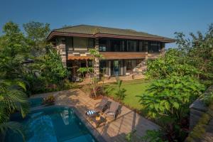 a house with a swimming pool in front of it at SaffronStays Rockford Manor in Āmbavna
