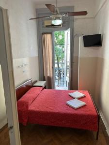 a bedroom with a red bed with a red blanket at Recoleta 680 in Buenos Aires