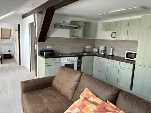 ein Wohnzimmer mit Couch und Küche in der Unterkunft Sylvias Ferienwohnung Nr7 DG in Görlitz