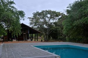 a swimming pool in front of a house at Kumbukgaha Villa in Sigiriya