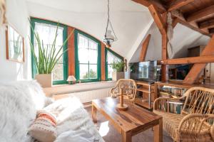 un salon avec un canapé et une table dans l'établissement Ferienwohnungen "Zur Linde am Achterwasser", à Zempin