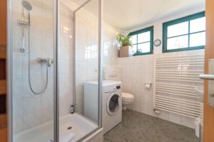 une salle de bains avec lave-linge et toilettes dans l'établissement Ferienwohnungen "Zur Linde am Achterwasser", à Zempin 5 autres photos
