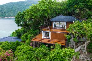 a house on top of a hill next to the water at Nangyuan Island Dive Resort in Ko Tao