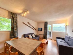a living room with a table and a couch at Appartement Flaine Forêt in Flaine