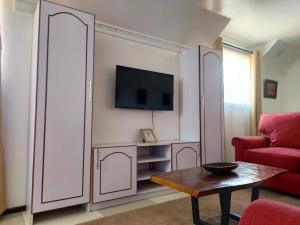 a living room with a red couch and a tv at Gerbera staycation in Nairobi