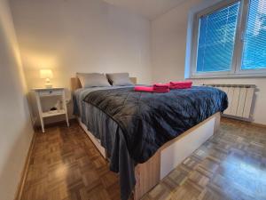 een slaapkamer met een bed met een zwarte deken erop bij RingPeace Apartment, Trnsko in Zagreb
