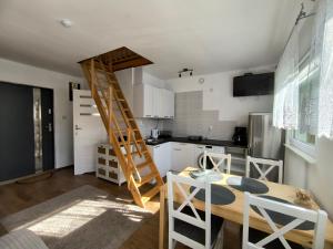 a kitchen with a ladder in the middle of a room at Holiday House Lawendowa Przystań - dom z jacuzzi nad jeziorem in Miszkowice