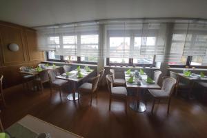 una sala da pranzo con tavoli, sedie e finestre di Eibacher Hof a Norimberga