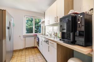 Una cocina con gabinetes blancos y electrodomésticos negros. en Gästezimmer Gross, en Tübingen