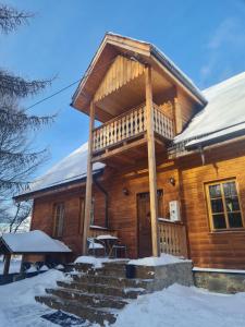 una baita con un portico coperto nella neve di Brejowka a Krynica-Zdrój