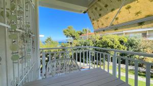 a balcony with a white chair on a porch at Luxury on the beach apartment in Hanioti