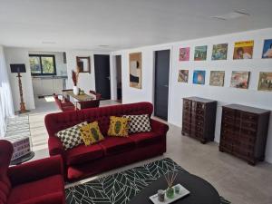 a living room with a red couch and a table at Casa Vieira in Fajã da Ovelha