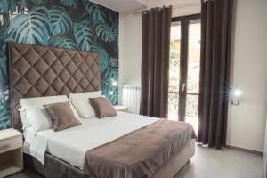 a bedroom with a large bed and a large window at Villa Porpora in Pompei
