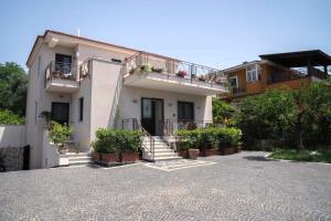 a white house with potted plants in a driveway at Villa Porpora in Pompei