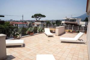 a patio with white lounge chairs on a roof at Villa Porpora in Pompei