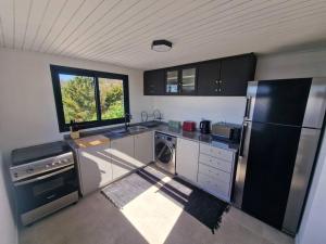 a kitchen with stainless steel appliances and a window at Casa Vieira in Fajã da Ovelha
