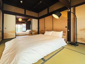 una camera da letto con un grande letto bianco di #12 -関ヶ原 蛍- 古民家の宿 a Sekigahara