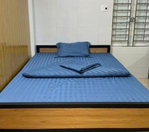 a bed with blue sheets and a blue pillow at Liam's homestay in Ha Giang