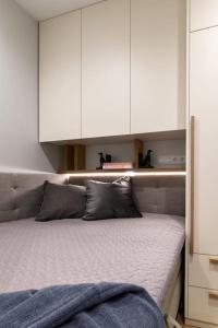 a bedroom with a bed with white cabinets at Cozy Quiet City Center Apartment in Klaipėda