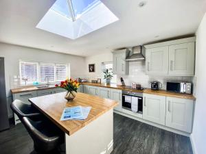 a kitchen with white cabinets and a table with flowers on it at Lakeway in Penrith