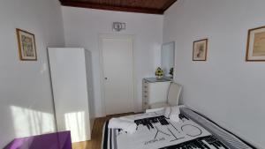 a white room with a bed and a refrigerator at Evergreen House - Japartments in Genova