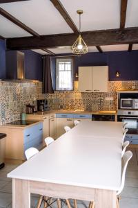 a kitchen with a white table and chairs at Domaine de Cantelou in Clécy