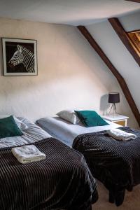 two beds in a room with a zebra picture on the wall at Domaine de Cantelou in Clécy +29 photos