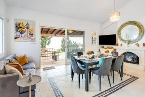 Una sala de estar con una mesa y sillas y un sofá. en Villa Aris by Ezoria Villas, en Tsadha
