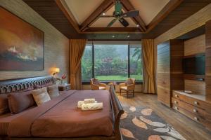 a bedroom with a large bed and a large window at SaffronStays Rockford Manor in Āmbavna