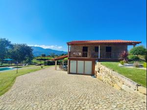 a house with a stone walkway in front of it at Casa doNegrinho com Piscina in Monção