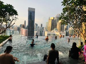 a group of people in a swimming pool with a city skyline at AXON Residences Kuala Lumpur in Kuala Lumpur