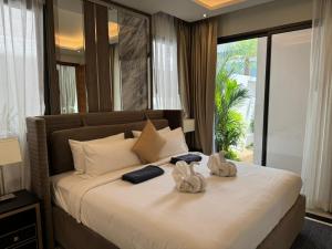 une chambre avec un grand lit avec des serviettes dessus dans l'établissement Luxury Breeze Villa with private pool & maid, à Ban Thalat Choeng Thale 19 autres photos