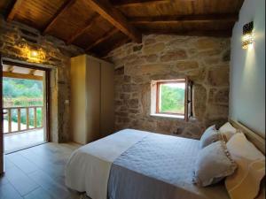 a bedroom with a large bed in a stone building at Casa doNegrinho com Piscina e Bungalow sem Piscina in Monção