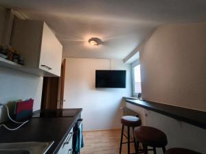 a kitchen with a sink and two stools in it at Alb Rooms - Einfache, gepflegte Zimmer auf der Schwäbischen Alb in Oberlenningen