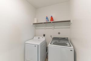 eine kleine Küche mit einer Waschmaschine und einem Regal in der Unterkunft Cozy 3 Bedroom Family Beach Home in Galveston in Galveston