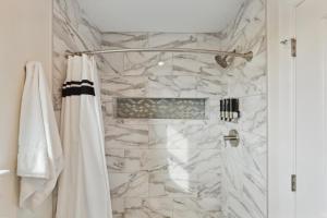 ein Bad mit einer Marmordusche mit einem Duschvorhang in der Unterkunft Cozy 3 Bedroom Family Beach Home in Galveston in Galveston + 12 Fotos