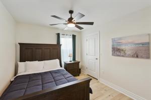 ein Schlafzimmer mit einem Bett und einem Deckenventilator in der Unterkunft Cozy 3 Bedroom Family Beach Home in Galveston in Galveston