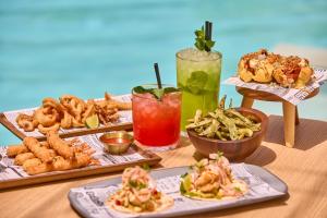 a table topped with plates of food and drinks at Hotel Astoria Playa Adults Only 4* Sup in Port d'Alcudia