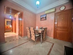 a dining room with a table and chairs and a clock at prestige andalouse 4 in Marrakesh