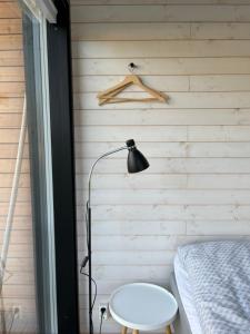 a bedroom with a bed and a lamp and a table at Willa Rauha G, minikoti rauhallisella sijainnilla, ei saunaa in Lumijoki