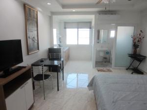 a bedroom with a bed and a desk and a television at DAO Studio Apartments in Patong Beach