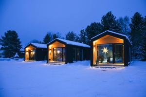 a couple of lodges in the snow at night at Willa Rauha G, minikoti rauhallisella sijainnilla, ei saunaa in Lumijoki +10 photos